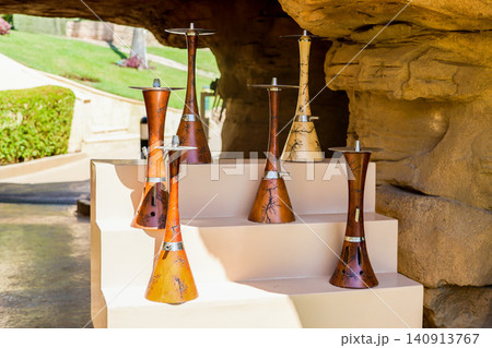 Assortment of hookahs neatly arranged on a shelf in a cozy summer cafe with relaxed ambiance 140913767