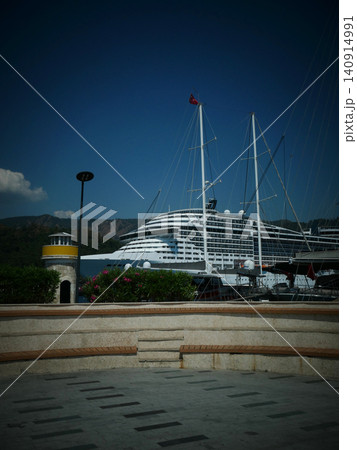 Large cruise ship docked at a harbor with small lighthouse Large cruise ship docked at a harbor with small lighthouse 140914991