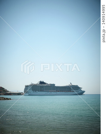 Large cruise ship anchored in calm blue sea near coastline 140914995