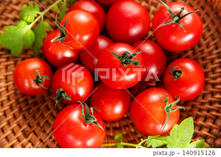 Cherry tomatoes resting in rustic wicker basket 140915126