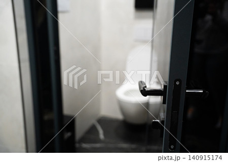 Modern restroom stall with open door and contemporary sanitary fixtures in a commercial office interior. Clean bathroom facilities for workplace and public buildings Modern restroom stall with open door and contemporary sanitary fixtures in a commercial office interior. Clean bathroom facilities for workplace and public buildings 140915174