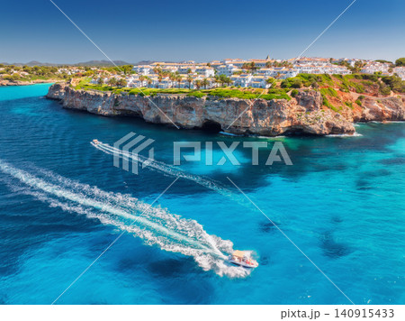 Aerial view of boat and white coastal resort with villas Aerial view of boat and white coastal resort with villas 140915433