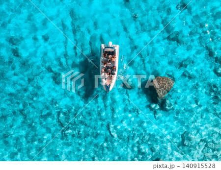 Aerial view of boat with people in clear blue sea in summer Aerial view of boat with people in clear blue sea in summer 140915528