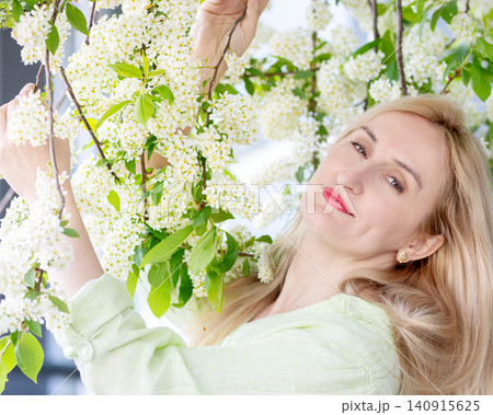 Portrait of a woman with natural beauty at the blooming tree in spring. 140915625