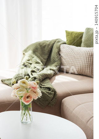 Ranunculus flowers decorating a cozy living room sofa area 140915704