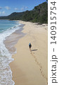 Alone woman wandering barefoot along sunriselit beach with peaceful surroundings 140915754