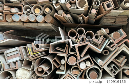Diverse collection of metal profiles, pipes stacked in workshop Diverse collection of metal profiles, pipes stacked in workshop 140916186