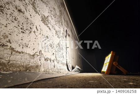 Portable floodlight illuminating damaged concrete wall at night Portable floodlight illuminating damaged concrete wall at night 140916258