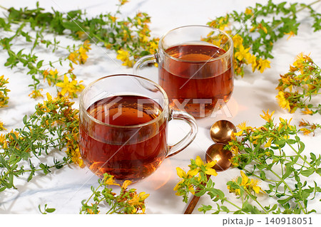 Hypericum infusion in glasses with a bouquet of flowers, medicinal herbal tea, alternative folk medicine concept, green pharmacy advertisement, a collection of beneficial herbs for folk medicine Hypericum infusion in glasses with a bouquet of flowers, medicinal herbal tea, alternative folk medicine concept, green pharmacy advertisement, a collection of beneficial herbs for folk medicine 140918051
