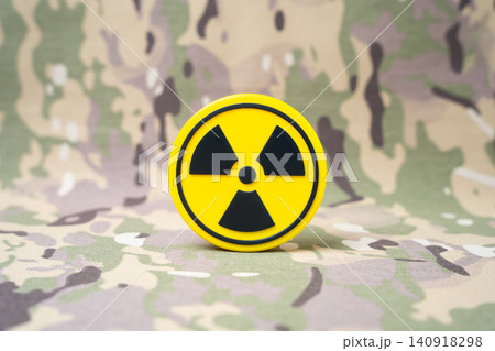 A radiation symbol on a military background. Nuclear deterrent weapons, deployment of carriers and infrastructure in third countries of military blocs. 140918298