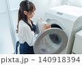 ドラム式洗濯機で洗濯をする主婦 140918394