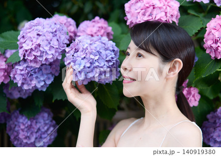 紫陽花に寄り添い季節を楽しむ笑顔の女性 紫陽花に寄り添い季節を楽しむ笑顔の女性 140919380