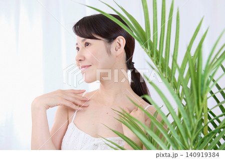 うっとりと首元を触れる美容イメージの女性 140919384