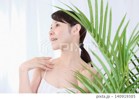 うっとりと首元を触れる美容イメージの女性 うっとりと首元を触れる美容イメージの女性 140919385