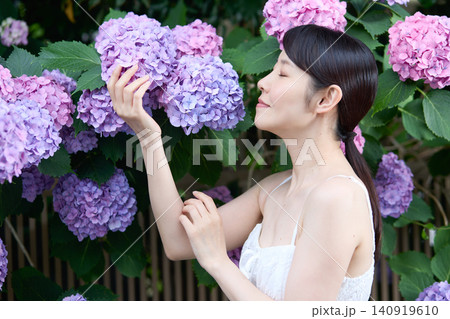 紫陽花を手に取り笑顔を見せる女性 紫陽花を手に取り笑顔を見せる女性 140919610