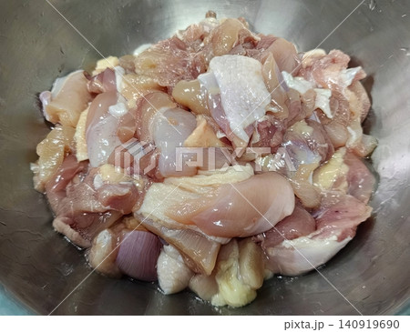 Fresh raw chopped chicken meat pieces in a stainless steel bowl for cooking Fresh raw chopped chicken meat pieces in a stainless steel bowl for cooking 140919690