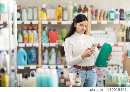 Adult woman scanning detergent barcode on phone Adult woman scanning detergent barcode on phone 140919861