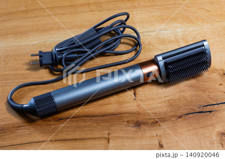 Modern thermal hair straightening brush on wooden surface 140920046