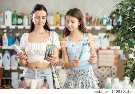 Woman with daughter choosing oral care products in supermarket Woman with daughter choosing oral care products in supermarket 140920130
