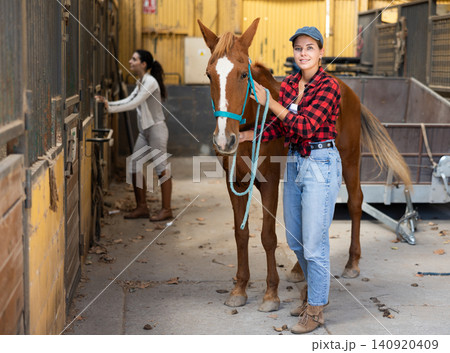 Young woman with horse in stable Young woman with horse in stable 140920409