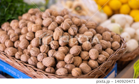 Pile of unshelled walnuts on store counter Pile of unshelled walnuts on store counter 140920471
