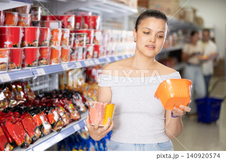 Asian girl chooses traditional Chinese noodles in supermarket Asian girl chooses traditional Chinese noodles in supermarket 140920574