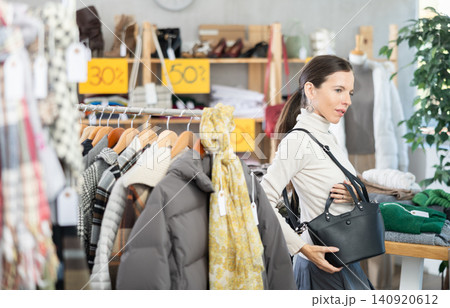 Adult woman choosing handbag in clothing store Adult woman choosing handbag in clothing store 140920612