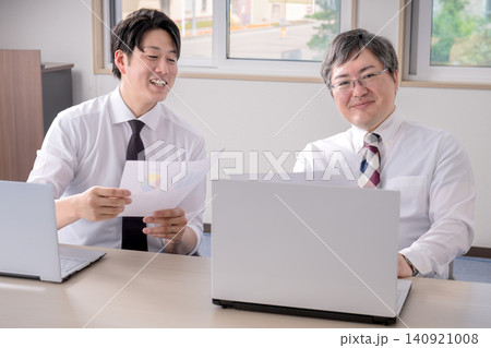 資料を見ながら笑う男性会社員二人 資料を見ながら笑う男性会社員二人 140921008