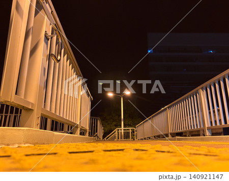 深夜の歩道橋とオレンジ色の街灯が印象的な都市風景、夜の安全な歩行空間のイメージ 深夜の歩道橋とオレンジ色の街灯が印象的な都市風景、夜の安全な歩行空間のイメージ 140921147