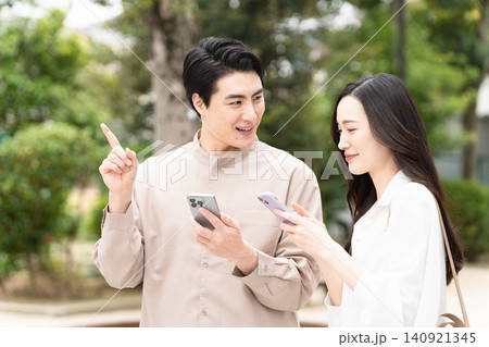 スマートフォンを操作している若い男女 ライフスタイルイメージ スマートフォンを操作している若い男女 ライフスタイルイメージ 140921345