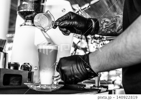 Barista at premium coffee shop preparing a Latte with professional equipment in Black & White Barista at premium coffee shop preparing a Latte with professional equipment in Black & White 140922819