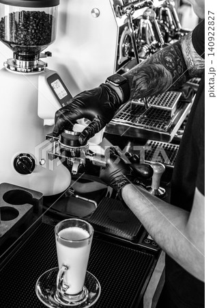 Barista at premium coffee shop preparing a Latte with professional equipment in Black & White Barista at premium coffee shop preparing a Latte with professional equipment in Black & White 140922827