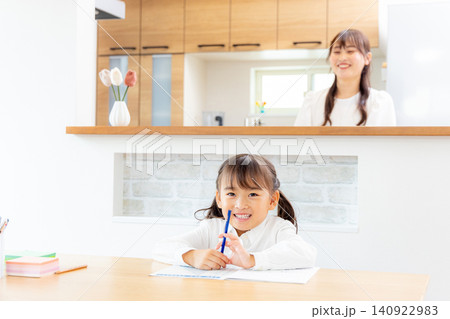リビングで勉強をする子どもと見守る母 リビングで勉強をする子どもと見守る母 140922983