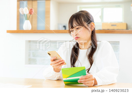 家計簿をつける若い女性 140923023
