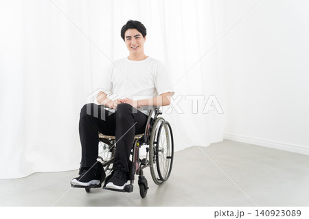 怪我で車椅子に乗る若い男性 怪我で車椅子に乗る若い男性 140923089