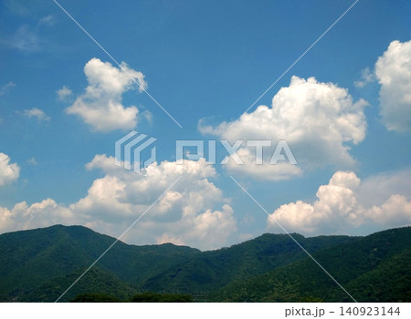 夏空に浮かぶ入道雲と緑の山並みの風景 140923144