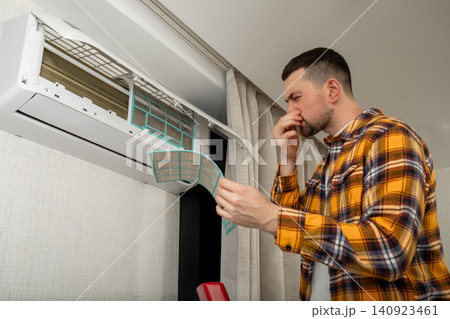 Air conditioner technician checks air filter in indoor space 140923461