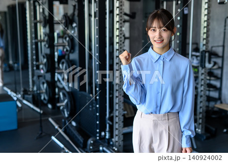 仕事帰りにジムに通うオフィスカジュアルの若い女性 筋トレ女子 通う ガッツポーズ 仕事帰りにジムに通うオフィスカジュアルの若い女性 筋トレ女子 通う ガッツポーズ 140924002