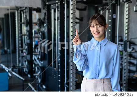 仕事帰りにジムに通うオフィスカジュアルの若い女性 筋トレ女子 通う 指差し 案内 仕事帰りにジムに通うオフィスカジュアルの若い女性 筋トレ女子 通う 指差し 案内 140924018