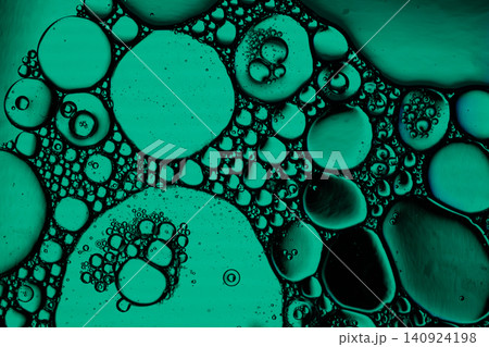 Macro view of teal liquid droplets clustered on dark background, creating organic circular cells, glossy surfaces, and scientific abstract texture Macro view of teal liquid droplets clustered on dark background, creating organic circular cells, glossy surfaces, and scientific abstract texture 140924198