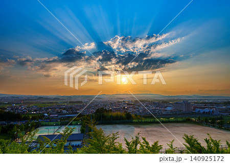京都府南部南山城の高台から望む夕景　薄明光線のように雲間から上空へ光を投げかける夕日 140925172
