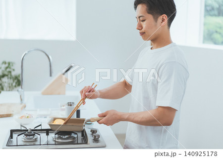 お弁当を節約のために自分で作る若い男性 お弁当を節約のために自分で作る若い男性 140925178