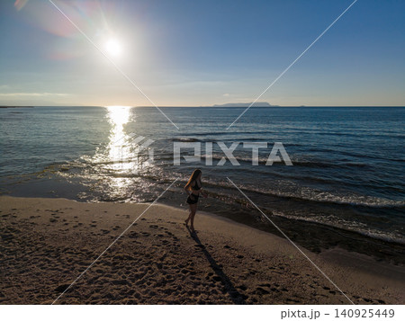 Young Woman Jogging on Sandy Beach at Sunrise along Sea Young Woman Jogging on Sandy Beach at Sunrise along Sea 140925449