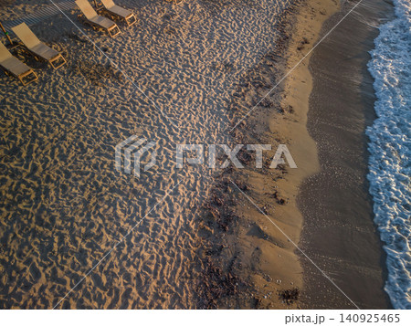 High Angle Drone View of Sandy Beach with Sunbeds at Sunset High Angle Drone View of Sandy Beach with Sunbeds at Sunset 140925465