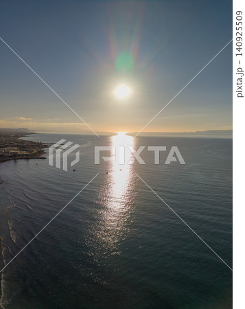 Bright Sunset Over Ocean Surface Near Coastal Resort Town Bright Sunset Over Ocean Surface Near Coastal Resort Town 140925509