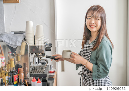 カフェでコーヒーを淹れる笑顔の女性店員 140926081