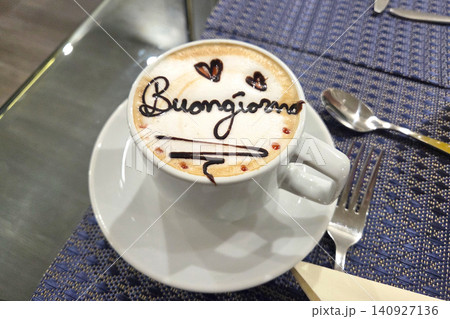 Coffee cup with greeting written in foam on a table at a cafe in the morning during brunch time 140927136