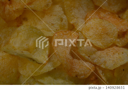 Crunchy golden potato chips offer a delightful snack experience at a cozy gathering on a sunny afternoon Crunchy golden potato chips offer a delightful snack experience at a cozy gathering on a sunny afternoon 140928631