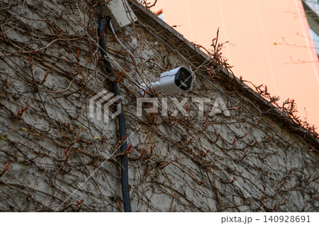 IP security camera mounted on building wall with Power over Ethernet PoE connection IP security camera mounted on building wall with Power over Ethernet PoE connection 140928691