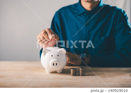 Global economy money bank piggy finance stock growth business concept save invest economic strategy helps man put coin in piggy bank for long term wealth and financial stability Global economy money bank piggy finance stock growth business concept save invest economic strategy helps man put coin in piggy bank for long term wealth and financial stability 140929010